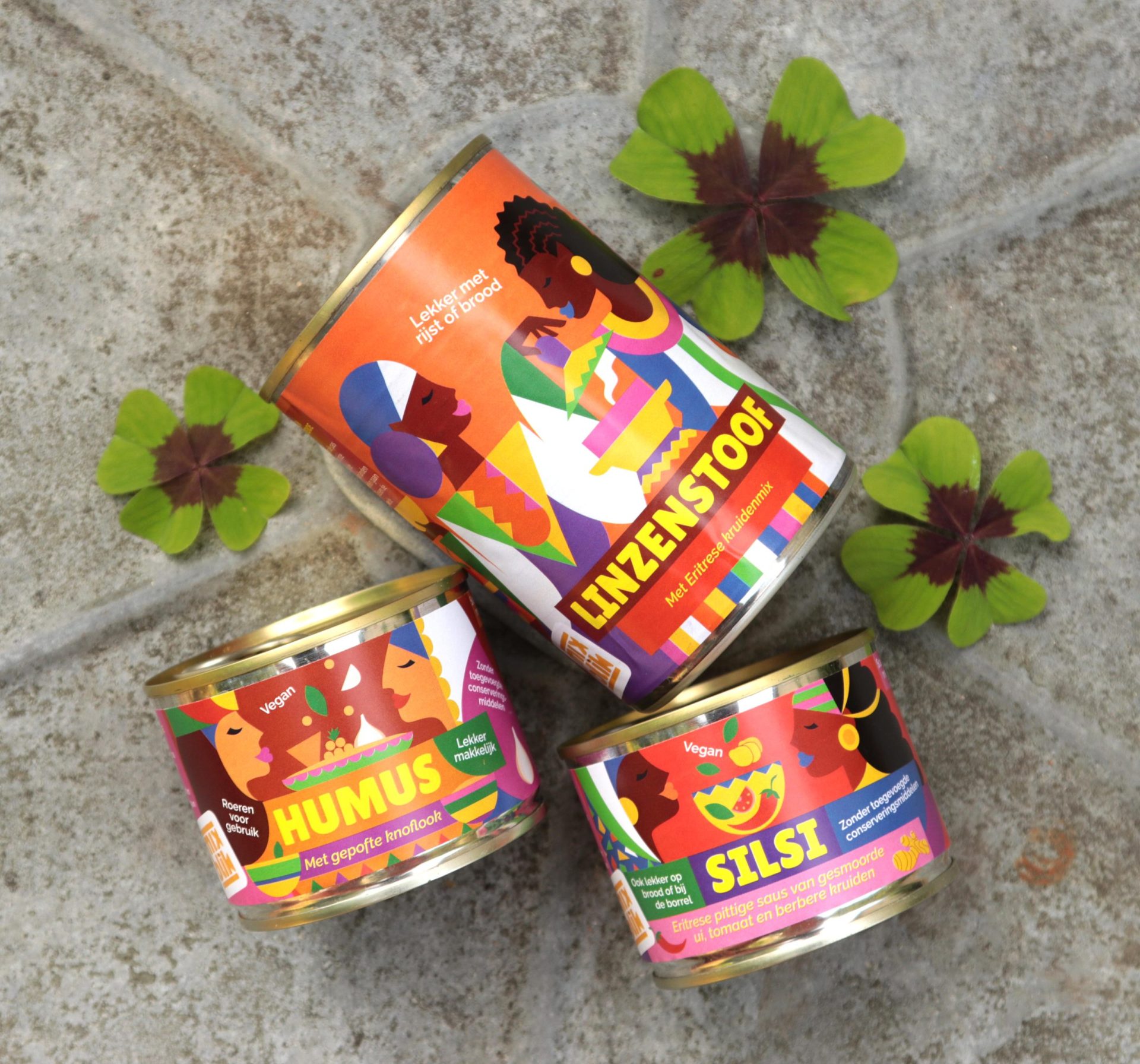 Mixblik blikken linzenstoof, humus klein en silsi klein op tegels omringd door bloemen